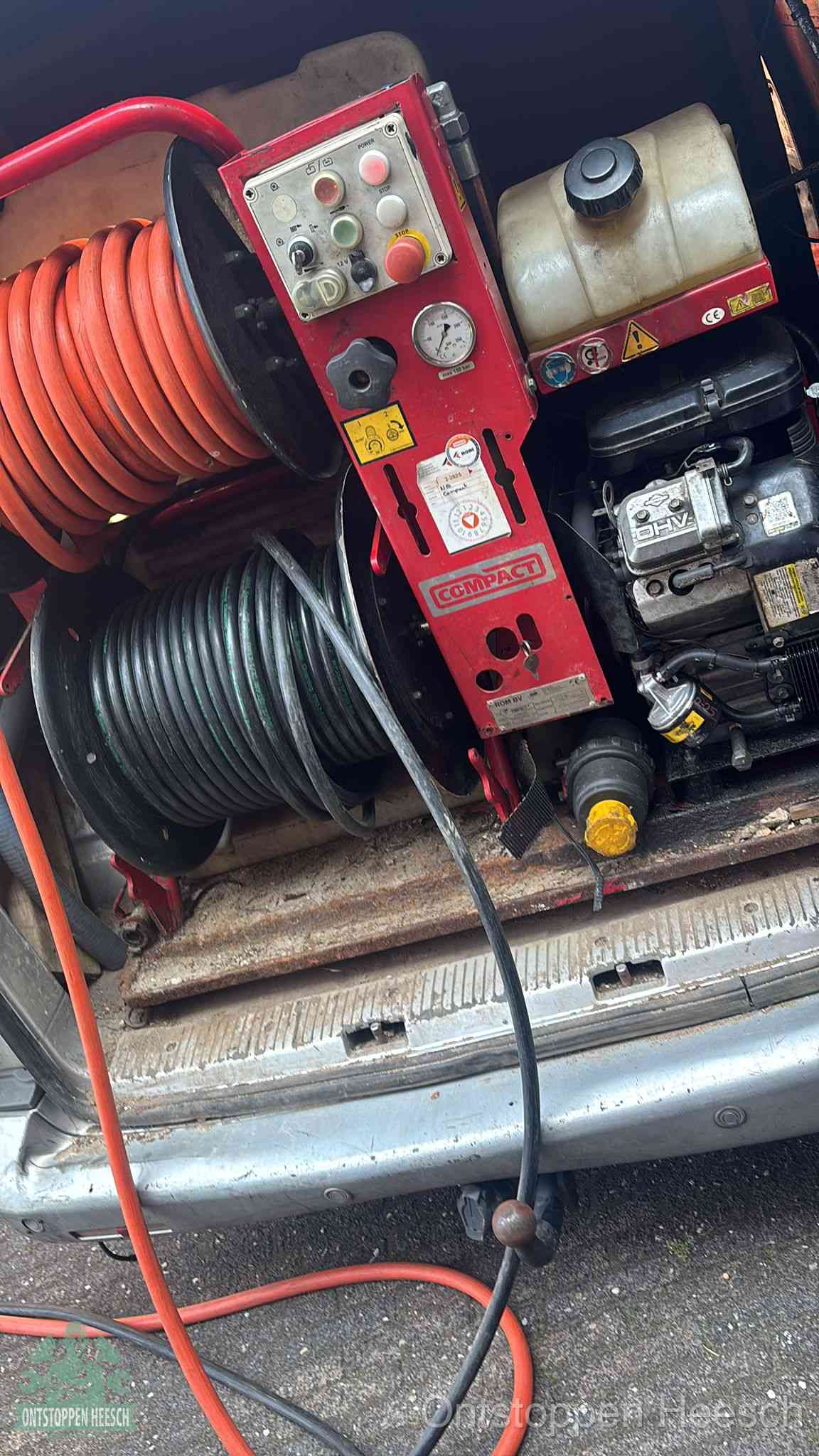 Een rood hogedruk-rioolreinigingstoestel in de laadbak van de bedrijfsbus, apparatuur voor een hardnekkige afvoerverstopping in Heesch