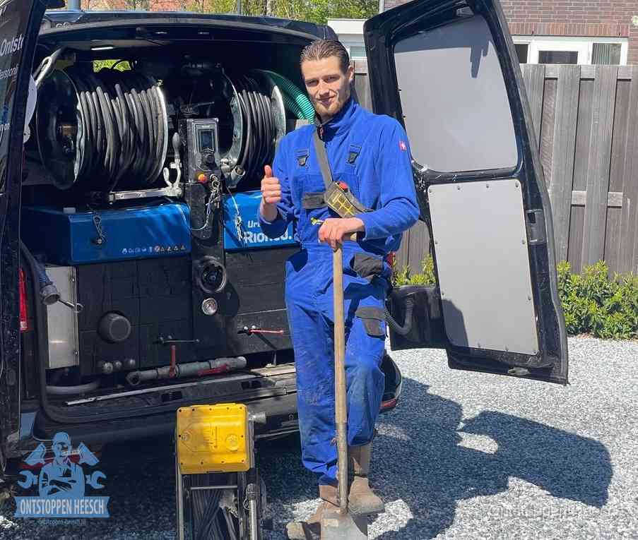 Een monteur bij de werkbus met grote hogedruk-slanghaspels, apparatuur voor hardnekkige afvoerverstoppingen in Heesch