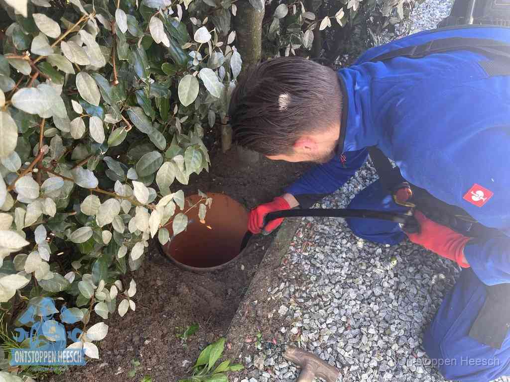 Monteur reinigt een rioolput met een slang, periodieke rioolreiniging in Heesch