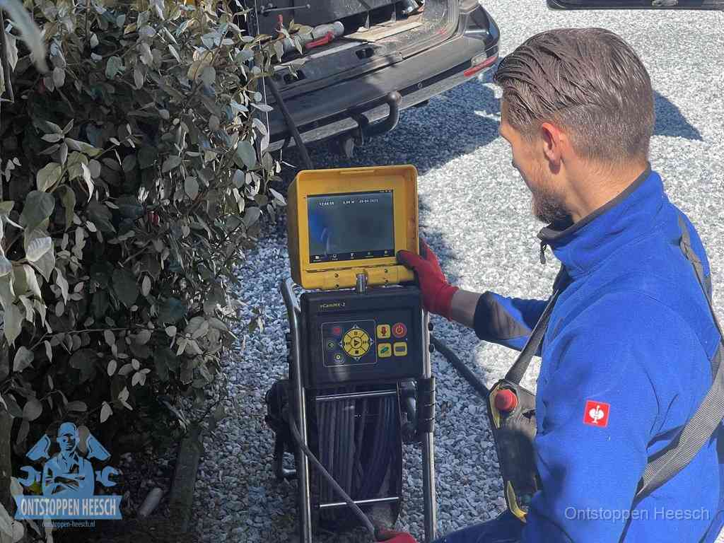 Monteur bedient een rioolinspectiecamera met monitor voor rioolinspectie in Heesch