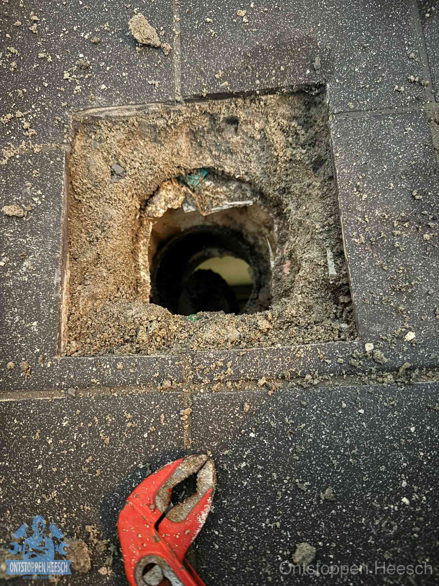 Geopend rioolputje op de erfgrens dat laat zien wie eigenaar is van de riolering in Heesch