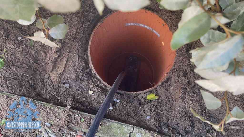 Open inspectieput in de tuin waar een veer rioolvliegjes en stankoverlast aanpakt in Heesch