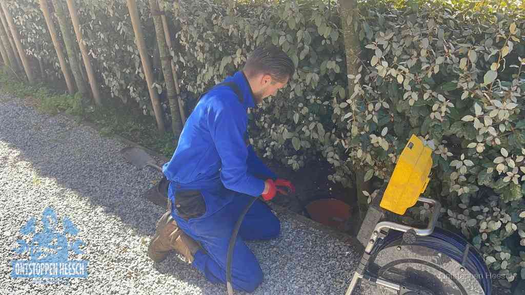 Monteur aan het werk bij een rioolput, de werkwijze voor riool ontstoppen in Heesch
